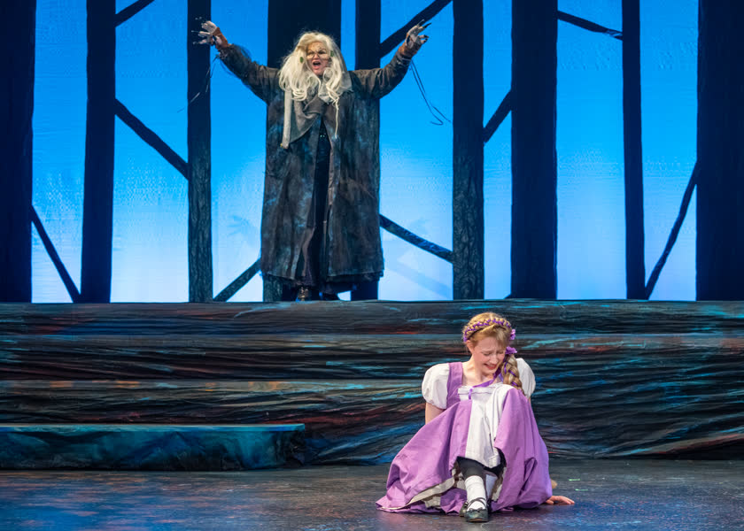 A student performing in a school theatre production.