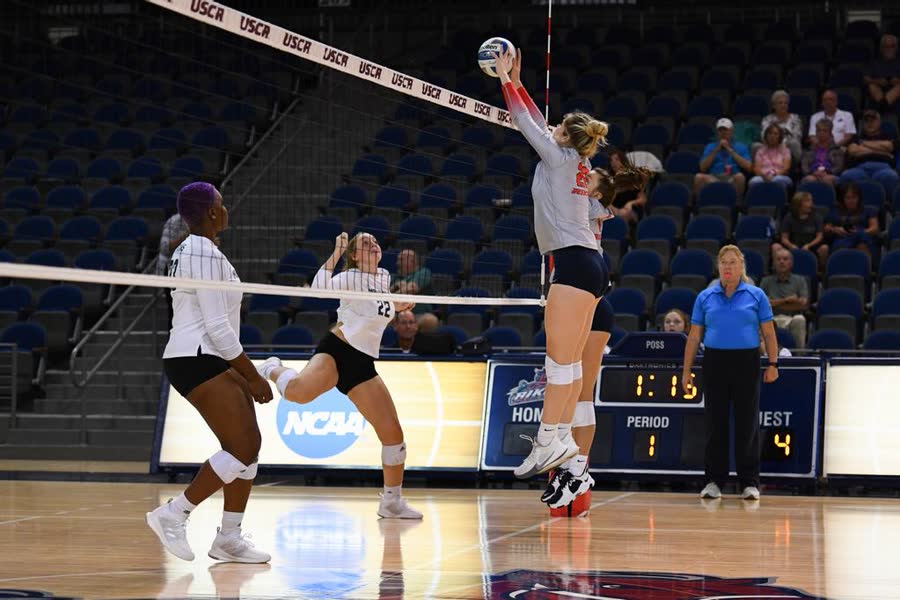 A student competing in a college volleyball match.