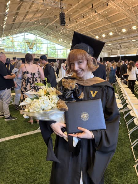 A student on graduation day holding her diploma.